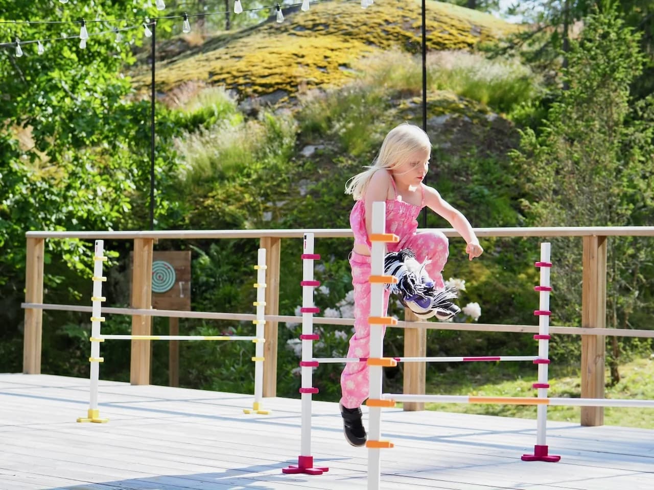 Lapsi hyppii Hoppi-hyppyesteiden yli keppihevosella thumbnail